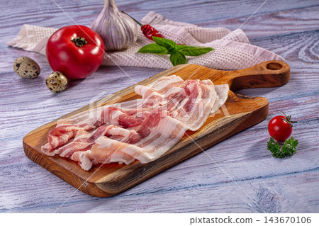 Wooden cutting board, raw pork bacon strips, breakfast meat ingredient Wooden cutting board, raw pork bacon strips, breakfast meat ingredient 143670106