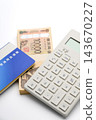 A calculator, a bankbook, and a 10,000 yen bill. 143670227