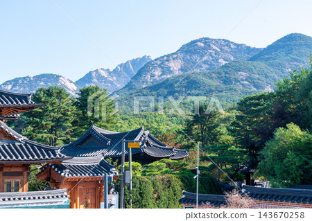 Traditional Korean Hanok Houses and Tiled Roofs against Bukhansan Mountain in Eunpyeong Hanok Village, Seoul Traditional Korean Hanok Houses and Tiled Roofs against Bukhansan Mountain in Eunpyeong Hanok Village, Seoul 143670258