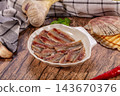 Marinated anchovy fillets in white ceramic bowl with garlic, red chili and seashell on rustic wooden table, seafood appetizer 143670376