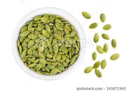 Peeled pumpkin seeds in ceramic bowl isolated on white background. Top view. Flat lay Peeled pumpkin seeds in ceramic bowl isolated on white background. Top view. Flat lay 143671945