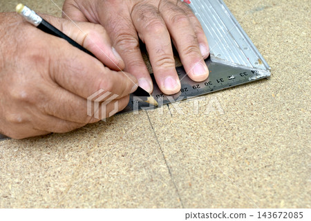 The process of marking a line on a particleboard panel The process of marking a line on a particleboard panel 143672085