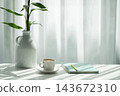 coffee cup and green notebook and plant pot arranged on white table with window curtain 143672310