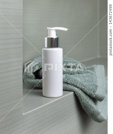 White cosmetic borttle mockup on light green towel in bathroom, unbranded packaging White cosmetic borttle mockup on light green towel in bathroom, unbranded packaging 143672499
