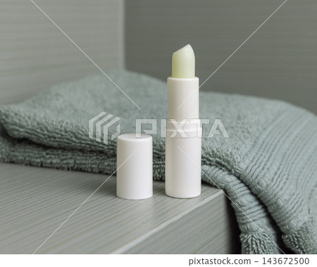 Open lip balm stick with a lid mockup in green bathroom. Herbal cosmetic product for home use Open lip balm stick with a lid mockup in green bathroom. Herbal cosmetic product for home use 143672500