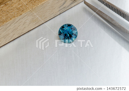 macro mineral faceted stone Sapphire on a gray background macro mineral faceted stone Sapphire on a gray background 143672572