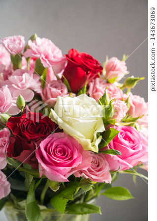 Mixed pink, red and white roses with carnations in a lush floral bouquet Mixed pink, red and white roses with carnations in a lush floral bouquet 143673069