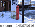 一個紅色的消防栓矗立在白雪皚皚的街角。 143673616