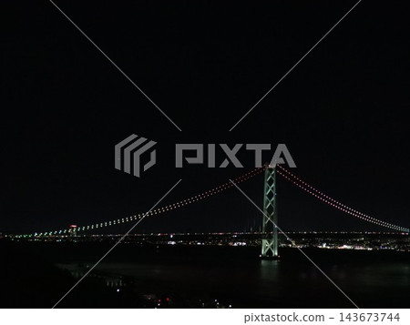 The Akashi Kaikyo Bridge at night, spanning the dark sea. 143673744
