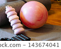 Home gym essentials on a yoga mat ankle weights, water bottle and pilates ball staged for a mindful indoor workout promoting wellness and everyday fitness routine. 143674041