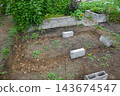 Cinder blocks laid out on excavated ground, marking the foundation for a new raised garden bed construction 143674547