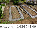 Building concrete footings for two garden raised beds, preparing foundation for cinder block construction 143674549