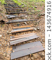 Rustic wooden staircase built on muddy hill in tropical nature 143674916