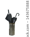 Two black umbrellas are placed inside a metal umbrella stand. 143675888