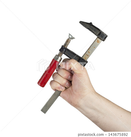 A hand holds a C-clamp with a red handle. A hand holds a C-clamp with a red handle. 143675892