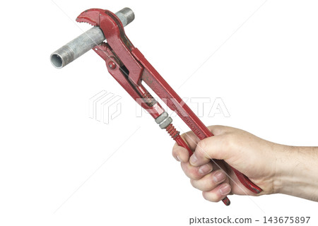 A hand holds a red pipe wrench gripping a metal pipe A hand holds a red pipe wrench gripping a metal pipe 143675897