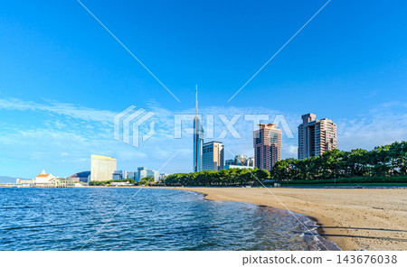A view of Momochihama beach with a wide blue sky and Fukuoka Tower in the background. A view of Momochihama beach with a wide blue sky and Fukuoka Tower in the background. 143676038
