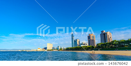The cityscape of Fukuoka with a view of Momochihama Beach under a wide blue sky and Fukuoka Tower. The cityscape of Fukuoka with a view of Momochihama Beach under a wide blue sky and Fukuoka Tower. 143676042