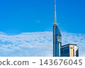 The exterior of Fukuoka Tower, soaring against a backdrop of blue sky and clouds. 143676045