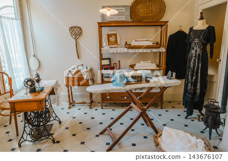 Period laundry and sewing room with sewing machine, ironing board and dress on a mannequin at Casa Mila Period laundry and sewing room with sewing machine, ironing board and dress on a mannequin at Casa Mila 143676107