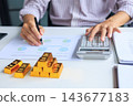 Close-up hands using calculator for gold bar trading analysis. Concept for wealth management, asset protection, and financial planning. 143677183