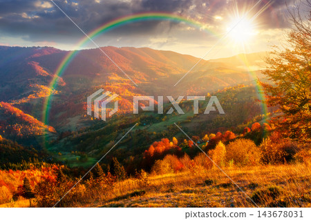 sunset over mountainous countryside landscape. dramatic sky above the distant valley. colorful fields and trees on the hill. beautiful nature landscape of Carpathians under rainbow sunset over mountainous countryside landscape. dramatic sky above the distant valley. colorful fields and trees on the hill. beautiful nature landscape of Carpathians under rainbow 143678031
