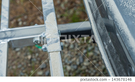 Close up of weathered metal brackets and bolts connecting rectangular frame elements outdoors in a detailed industrial construction structure Close up of weathered metal brackets and bolts connecting rectangular frame elements outdoors in a detailed industrial construction structure 143678146