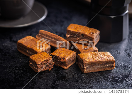 Close-Up Stack Of Chewy Chocolate Brownies With Crumbly Texture On Dark Surface Close-Up Stack Of Chewy Chocolate Brownies With Crumbly Texture On Dark Surface 143678374