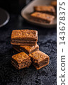 Close-Up Stack Of Chewy Chocolate Brownies With Crumbly Texture On Dark Surface 143678375