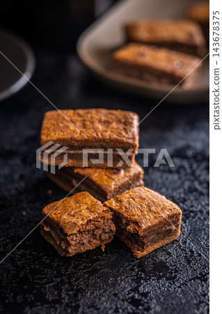 Close-Up Stack Of Chewy Chocolate Brownies With Crumbly Texture On Dark Surface Close-Up Stack Of Chewy Chocolate Brownies With Crumbly Texture On Dark Surface 143678375