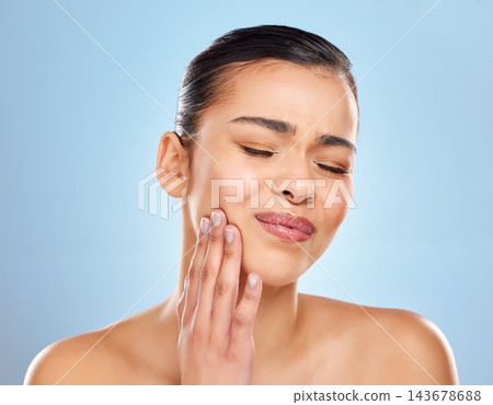 Toothache, pain and woman in studio with dental problem for cavity crisis and decay from bacteria. Female person, hand on face and jaw injury with surgery for teeth extraction by blue background 143678688