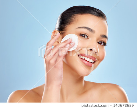 Skincare portrait, woman and cotton pad for beauty toner, natural shine and healthy glow in studio. Girl, isolated model and dermatology with makeup remover swab for cleaning face by blue background Skincare portrait, woman and cotton pad for beauty toner, natural shine and healthy glow in studio. Girl, isolated model and dermatology with makeup remover swab for cleaning face by blue background 143678689