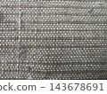 Close-up of coarse woven fabric texture with beige twisted brown threads and white weft yarns in a tight checkered pattern 143678691