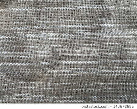 Rough woven textile close-up with tan fibrous yarns and thin white horizontal stripes, full frame natural-look fabric background 143678692