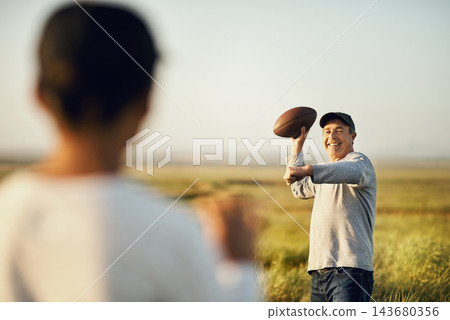 Son, man and sports with football in nature for outdoor teaching, child development and practice together. Smile, dad and throw with kid on grass field for bonding, exercise and fathers day in Texas Son, man and sports with football in nature for outdoor teaching, child development and practice together. Smile, dad and throw with kid on grass field for bonding, exercise and fathers day in Texas 143680356