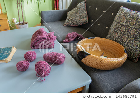 Pink Yarns and Knitted Pieces on a Table at Home Pink Yarns and Knitted Pieces on a Table at Home 143680791