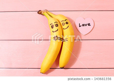 Funny lovestruck bananas hugging each other, featuring cheerful eyes and a little heart with the word love on it. A playful treat for kids and a creative serving idea for parties, birthdays. Funny lovestruck bananas hugging each other, featuring cheerful eyes and a little heart with the word love on it. A playful treat for kids and a creative serving idea for parties, birthdays. 143681356