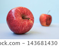 Fresh young apple in focus and old rotten apple blurred behind, light blue background, copy space. Concept of youth and aging, fresh versus spoiled, quality choice, food safety, life cycle 143681430
