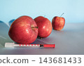 Fresh young apples beside syringe with wrinkled apple behind on light blue background, copy space. Concept of anti-aging, cosmetology injections, rejuvenation, skin care, youth and aging 143681433