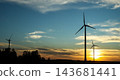 Silhouettes of wind turbines in field at sunset with blue sky and clouds, large copy space. Concept of renewable energy, green power, sustainability, climate change, energy transition 143681441