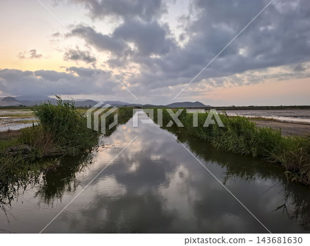 Irrigation Canal Reflecting Dramatic Cloudy Sunset in Countrysid 143681630
