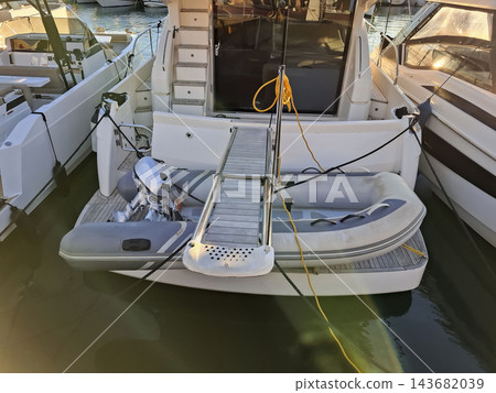 Stern of luxury motor yacht with dinghy tender and gangway 143682039