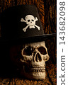 Halloween human skull, an image of a human skull wearing a hat in a setting of very old rustic wood, selective focus. 143682098