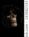 Human skull for Halloween, an image of a human skull in a macabre setting with fabric draped over the head to represent death, selective focus. 143682143