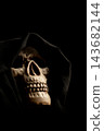 Human skull for Halloween, an image of a human skull in a macabre setting with fabric draped over the head to represent death, selective focus. 143682144