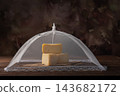 Semi-aged cheeses,beautiful and delicious semi-aged cheeses at various stages of maturation covered with fine cloth and resting on a rustic wooden table; selective focus. 143682172