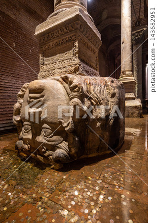 Istanbul,turkey,august 6, 2025. Ancient medusa head stone sculpture supporting a column, surrounded by wishing coins in the historical basilica cistern, istanbul 143682951