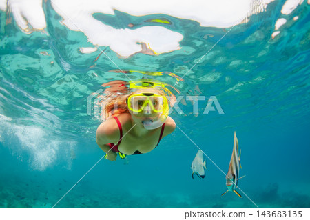 Happy family - active woman in snorkeling mask dive underwater, see tropical fishes in coral reef sea pool. Travel adventure, swimming activity and watersports on summer beach vacation with child. Happy family - active woman in snorkeling mask dive underwater, see tropical fishes in coral reef sea pool. Travel adventure, swimming activity and watersports on summer beach vacation with child. 143683135