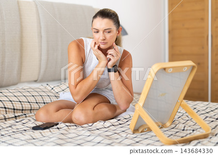 In bedroom girl looking at her reflection in mirror 143684330