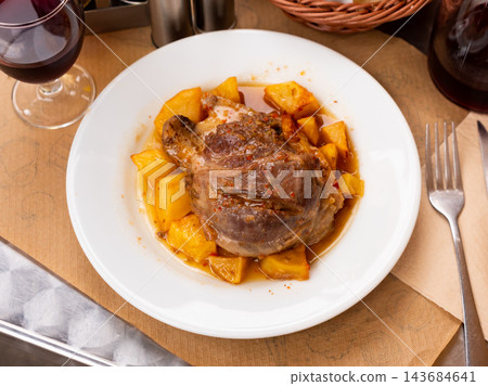 Stewed shank with boiled half potatoes served in a plate 143684641